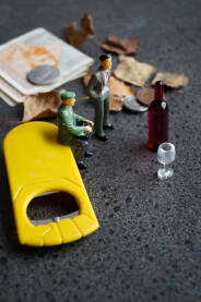 Ilustracija sa figurma ljudi koji gledaju u oborenu čašu i flašu pića. Novac i otvarač za flaše.