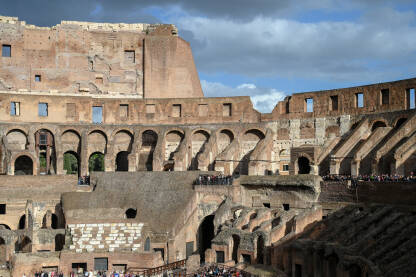 Rim, Italija. Koloseum u centru grada. Turisti u posjeti. Ljudi istražuju jednu od najpoznatijih znamenitosti na svijetu. Rimska arhitektura. Ljudi u Koloseumu.
