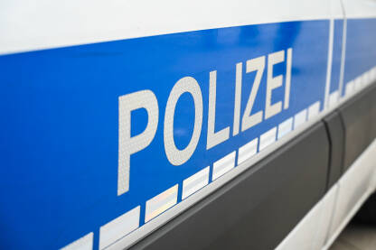 Policija, Njemačka Policijski patrolni automobil parkiran na ulici u Njemačkoj. Auto njemačke policije na ulici. Pogled sa strane na policijski automobil s natpisom "Polizei".