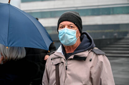 Čovjek sa medicinskom maskom tokom pandemije Covid-19. Čovjek sa medicinskom maskom tokom pandemije Covid-19. Stariji muškarac nosi masku za lice kao zaštitu od korona virusa.