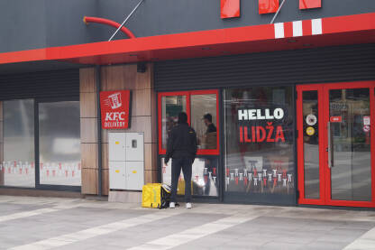 Dostava brze hrane, KFC restoran Dostavljač preuzima narudžbu u KFC restoranu brze hrane.