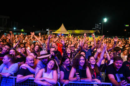 Grupa mladih na koncertu. Publika ispred bine na muzičkom festivalu. Grupa mladih na koncertu.