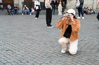 Turisti fotografiraju znamenitost na glavnom trgu. Žena s fotoaparatom.