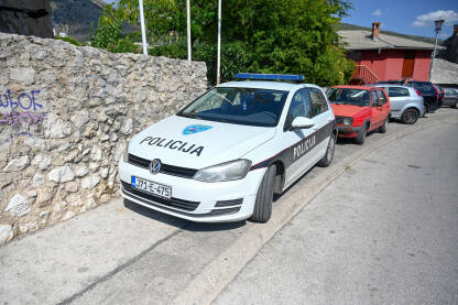 Policijsko vozilo na trotoaru Policijsko vozilo parkirano na trotoaru. Automobili parkirani na trotoaru. Saobraćajni prekršaj.