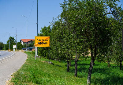 Tabla sa natpisom Laktaši Uništeni saobraćajni znak. Znak prefarban bojom. Latinični natpis mjesta Laktaši prešaran sprejom u boji.