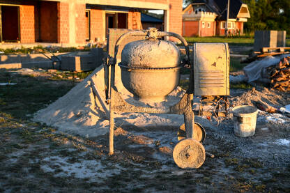Električna mješalica za beton uz kuću u izgradnji. Izgradnja kuće.