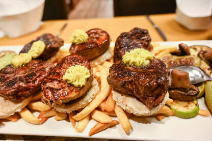 Pečeno meso u restoranu. Ukusna hrana. Miješano meso na pladnju. Večera.