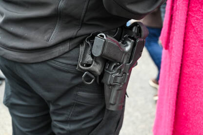 Pištolj na opasaču policajca. Pištolj na opasaču policajca. Pištolj u futroli pripadnika specijalne policije. Oružje.