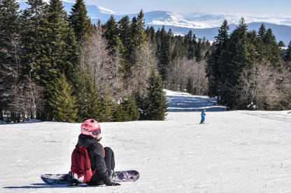 Djevojka na ski stazi Djevojka sjedi na ski stazi. Skijalište Kupres.