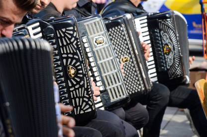 Muzičari sviraju harmoniku Muzičari sviraju harmoniku. Muzički instrument.