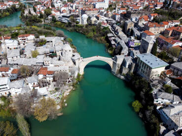 Stari most Stari most i rijeka Neretva u Mostaru, Bosna i Hercegovina. Panoramski snimak dronom, grad Mostar u proljeće.