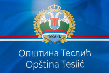 Grb, opština Teslić Grb Opštine Teslić na plavoj pozadini sa latiničnim i ćiriličnim natpisom Opština Teslić. Krupni kadar.