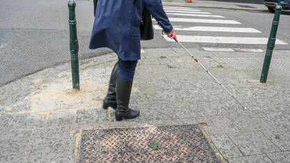 Slabovidna ili slijepa osoba prelazi ulicu uz pomoć bijelog štapa. Slijepa žena hoda ulicom koristeći bijeli štap.
