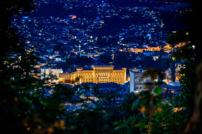 Sarajevska Vijećnica snimljena tokom noći. Plavi sat u Sarajevu. Noćna panorama Sarajeva i obasjana Vijećnica. Pogleda sa magistralnog puta na Sarajevo.