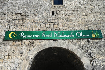 Natpis: Ramadan Serif Mubarek Olsun. Natpis na baneru: Ramadan Serif Mubarek Olsun. Natpis na zgradi. Ramazanske čestitke. Mjesec Ramazana.