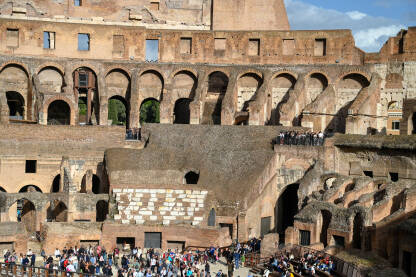 Rim, Italija. Koloseum u centru grada. Turisti u posjeti. Ljudi istražuju jednu od najpoznatijih znamenitosti na svijetu. Rimska arhitektura. Ljudi u Koloseumu.