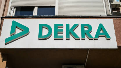 Natpis Dekra na zgradi. Logo. Natpis Dekra na zgradi. Dekra je njemačka organizacija za testiranje i pregled vozila. Logo.