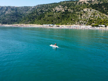 Turisti na pedalini na moru. Grupa ljudi se zabavlja na vodi tokom ljetnog odmora. Ljudi uživaju na moru.