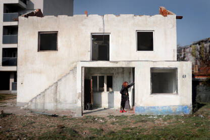 Romkinja plače za svojom kućom, dok je pored nje nova zgrada. 

Fotografija besplatna za ilustrovanje medijskih sadržaja o Romima, svako drugo korištenje je zabranjeno. 

Autorka: Svjetlana Panić