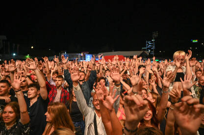 Publika s rukama u zraku Publika s rukama u zraku na koncertu. Mladi se zabavljaju na muzičkom festivalu. Live stage festival.