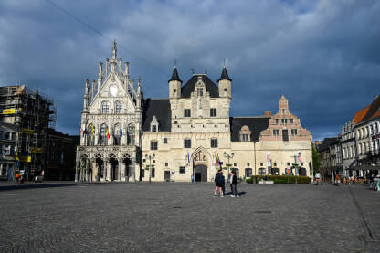 Mechelen, Belgija. Gradska vijećnica na glavnom trgu. Mechelen, Belgija: Zgrada gradske vijećnice na glavnom trgu u centru grada. Ljudi šetaju u gradu.