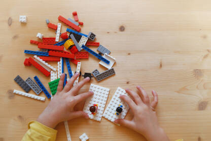 Djeca i igra Dječije ruke sa lego kockicama na stolu.