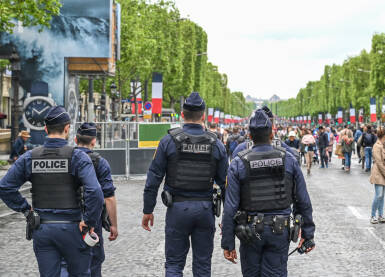 Specijalne policijske snage Francuske. Policajci u uniformama patroliraju gradom. Grupa policajaca u gradu. Francuski policajac.