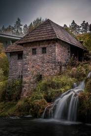 Rastoke Slapovi na Rastokama kod Slunja sa objektom i mostom u pozadini.