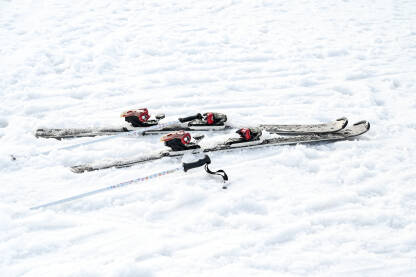 Skije i skijaški štapovi u snijegu Skije i skijaški štapovi u snijegu na planini. Zimski sport i rekreacija. Skijanje.