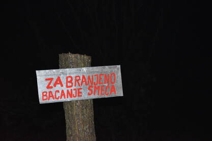 Znak za zabranjeno bacanje smeća Znak za zabranjeno bacanje smeća postavljen na posječeno drvo.