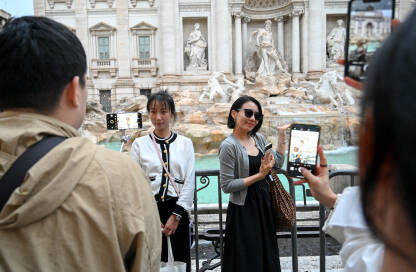 Rim, Italija: Turisti ispred Trevi fontane. Popularna znamenitost u Rimu. Mnogo turista ispred fontane u centru grada.