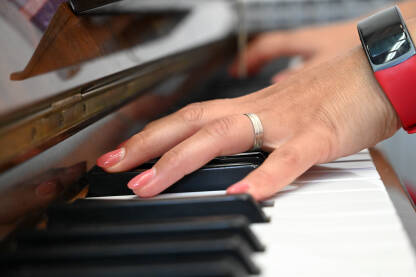 Žena svira piano u crkvi. Žena svira piano u crkvi. Krupni plan ruku muzičare koja svira klavir u katedrali. Religijska muzika.