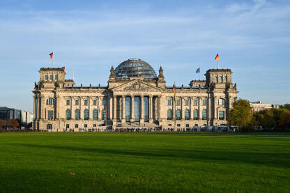 Parlament, Njemačka Berlin, zgrada njemačkog parlamenta. Zastave se vijore na jarbolu ispred zgrade Reichstaga u Berlinu, Njemačka. Njemački Bundestag.