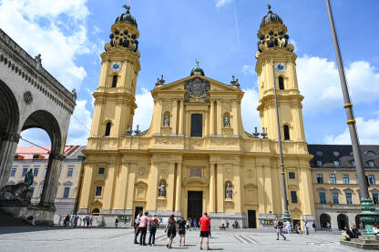 Minhen Minhen, Njemačka. Theatinerkirche je rimokatolička crkva na trgu Odeonsplatz. Crkva u centru grada i ljudi na trgu.