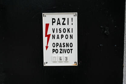 Natpis "visoki napon, opasno po život" Znak za opasnost od strujnog udara. Znak upozorenja na trafostanici. Natpis: Pazi. Visoki napon. Opasno po život.