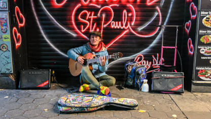 Hamburg, Sankt Pauli, Njemačka: Ulični pjevač i svirač. Ulični zabavljač svira gitaru na ulici.