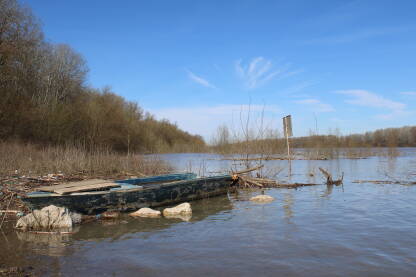 Drveni čamac na obali rijeke Save u Orašju. Uz čamac nakupine raznog otpada.