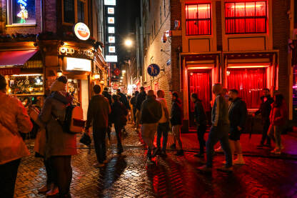 Amsterdam, Nizozemska: Turisti istražuju crvene četvrti u centru grada. Amsterdam, Nizozemska: Turisti istražuju crvene četvrti u centru grada. Popularno turističko odredište i mjesto gdje je prostitucija legalizirana. Ljudi noću hodaju ulicom