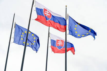 Zastave Slovačke i Evropske unije. Zastave Slovačke i Evropske unije ispred parlamenta u Bratislavi.Zastave Slovačke Republike i EU na jarbolu. Državni grb Slovačke.