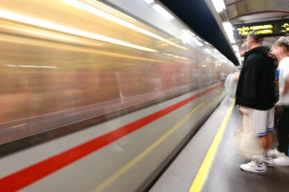 Metro/voz u pokretu Zamućena fotografija putnika na podzemnoj železničkoj stanici. Voz se brzo kreće. Željeznica. Javni prijevoz u gradu.