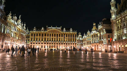 Brisel, Belgija: Ljudi na glavnom trgu u centru grada noću. Brussels - Grand Place je centralni trg. Osvijetljene historijske zgrade.