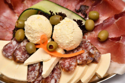 Meza servirana na inox tanjiru. Sir, kajmak, suva kobasica i pršut.