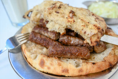 AKA_0837 Ćevapi ili ćevapčići. Tradicionalno mesno jelo u Bosni i Hercegovini. Meso pripremljeno na roštilju i posluženo s somunom (lepinjom) i lukom u restoranu. Popularna balkanska hrana.