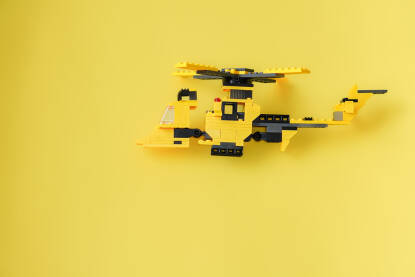 Igračka žuti lego helikopter Igračka žuti lego helikopter na žutoj pozadini