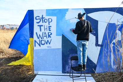 Natpis "Zaustavite rat odmah" sa ukrajinskom zastavom Umjetnik oslikava antiratne poruke. Podrška Ukrajini. Natpis: "Stop the war". Poljsko-ukrajinska granica.