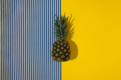 Svježi ananas na žutoj i prugastoj pozadini. Svježi ananas na žutoj i prugastoj pozadini.