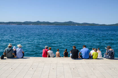 Grupa turista na odmoru na moru. Grupa turista na odmoru. Ljudi uz more.