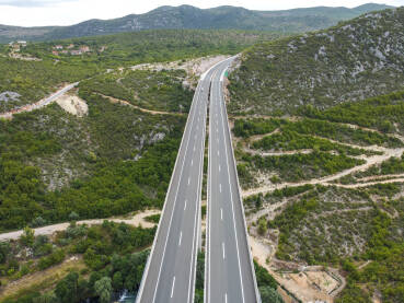 Vozila se kreću po visokom mostu na autoputu, snimak dronom. Saobraćaj na modernom vijaduktu na autoputu.