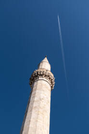Minaret Džamijski minaret naspram plavog neba, avion u letu