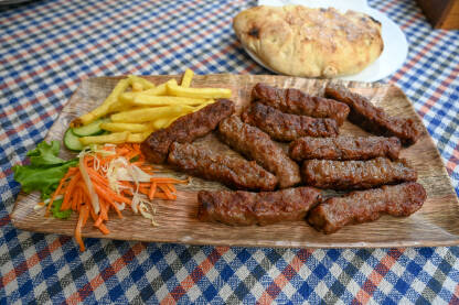 Ćevapi ili ćevapčići. Tradicionalno mesno jelo na Balkanu. Ćevapi ili ćevapčići. Tradicionalno mesno jelo na Balkanu. Meso pripremljeno na roštilju i servirano uz somun i povrće. Ćevapi u Skoplju, Sjeverna Makedonija.